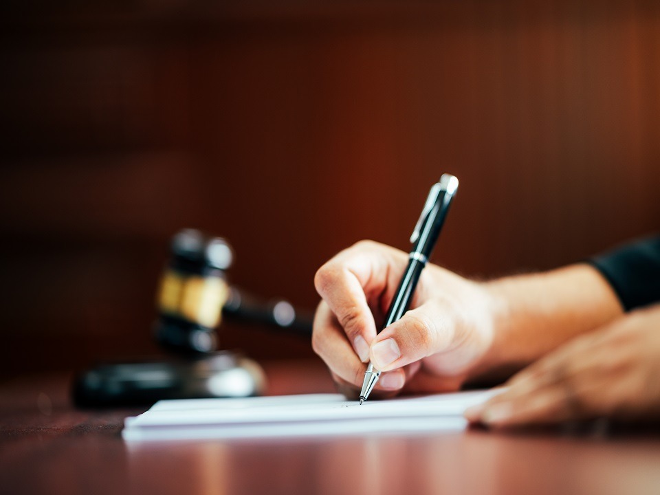 Lawyer holding a pen to write cases in the courtroom